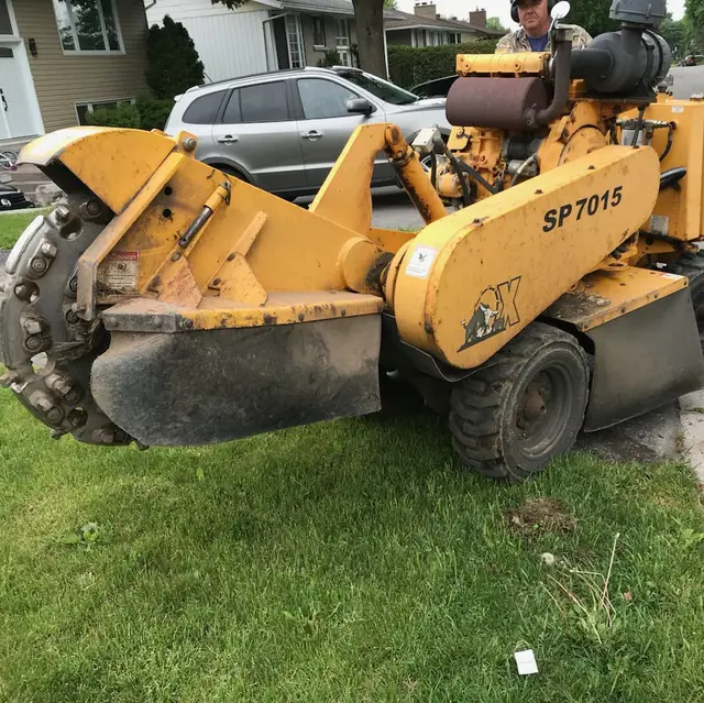 Stump grinding work near a fence